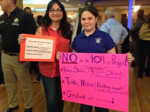 Devon Aire Paren and Student holding sign against Killian express toll ramp next to school in Kendall